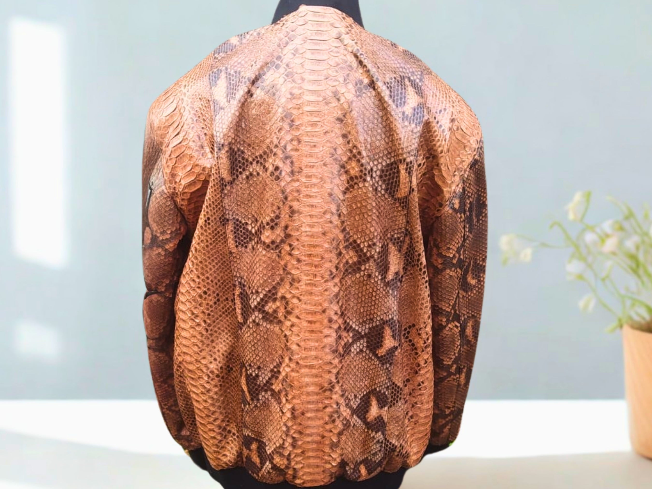 Brown leather bomber jacket back view with scaly snakeskin pattern and ribbed hem