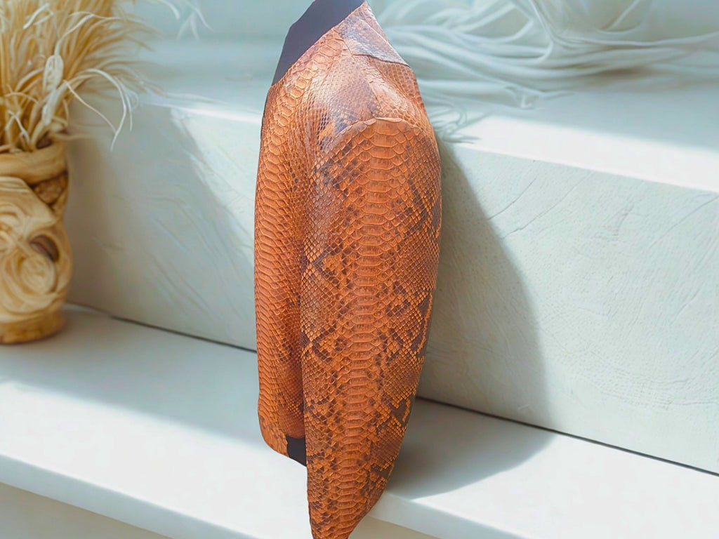 Brown leather bomber jacket side view with scaly snakeskin texture and ribbed cuffs