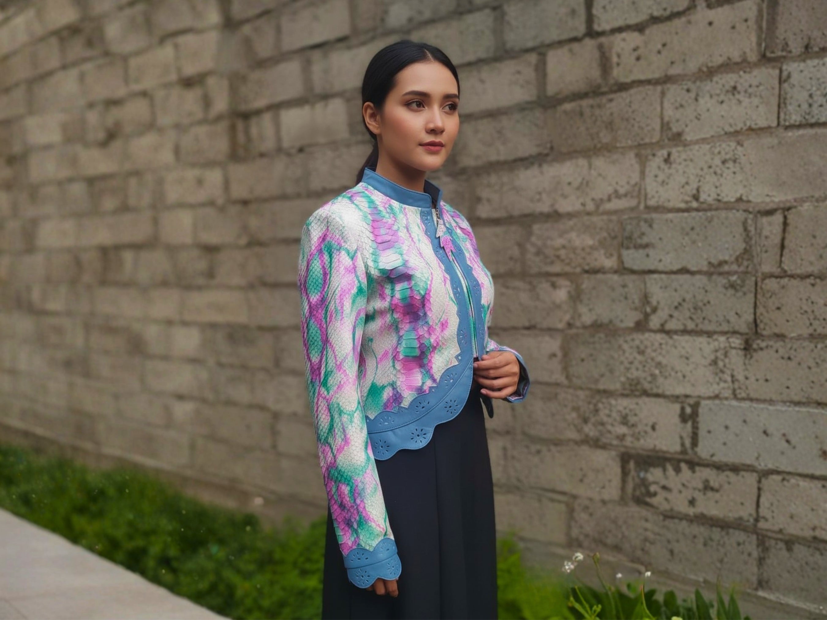 Cropped leather jacket with multicolor snakeskin tie-dye print and blue trim, side view