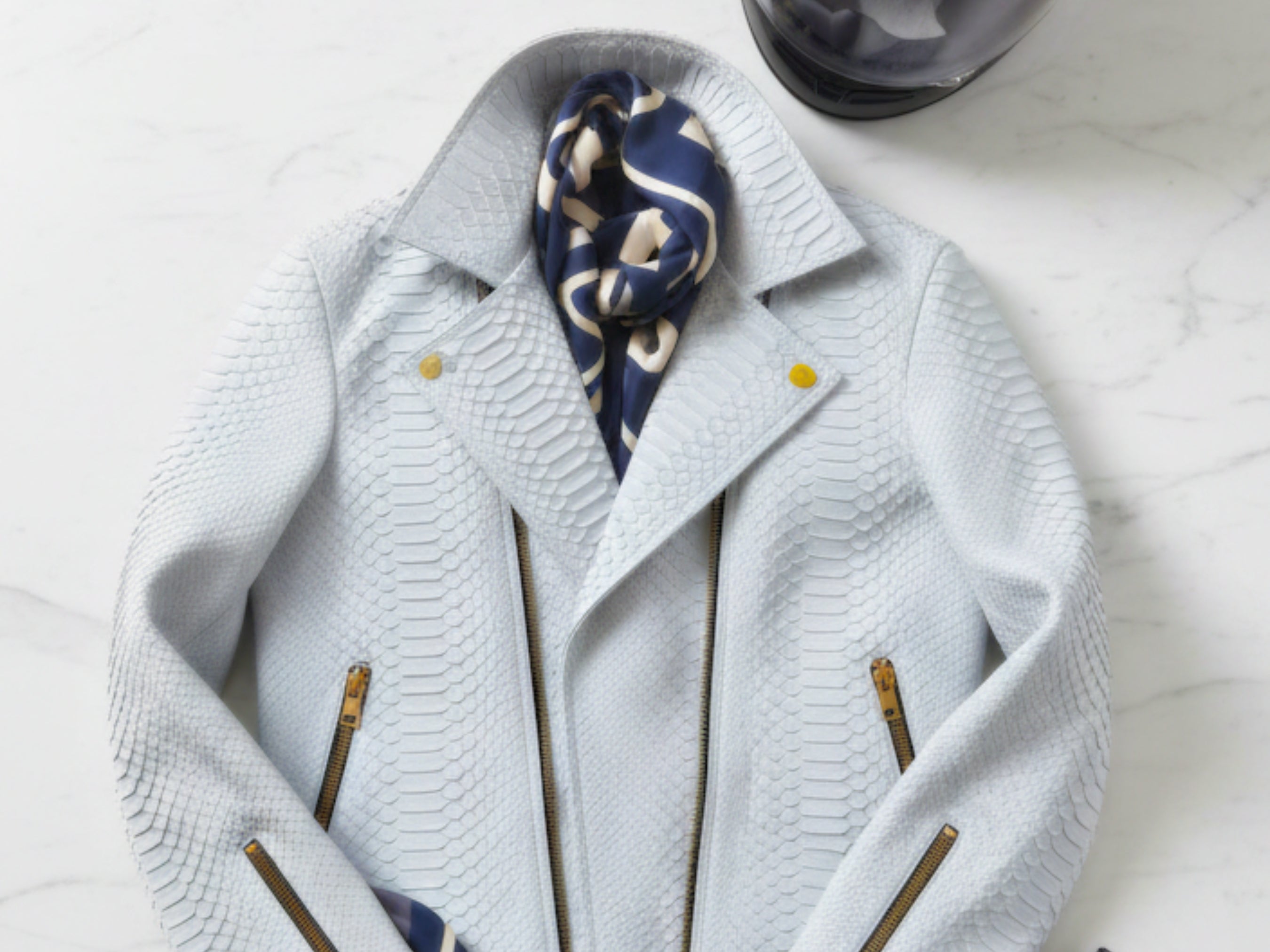 Light blue python-textured biker jacket close-up of lapels and gold zip pulls