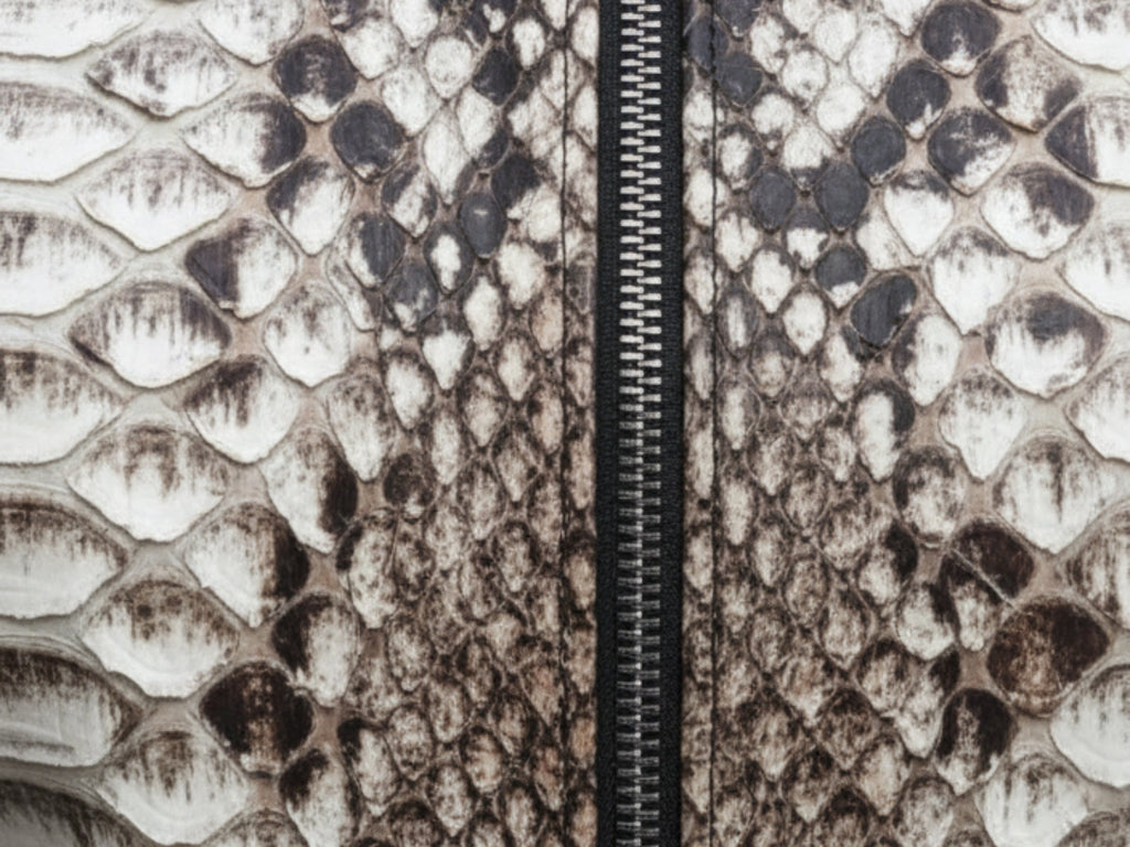 Close-up of gray-brown python-skin texture with black zipper