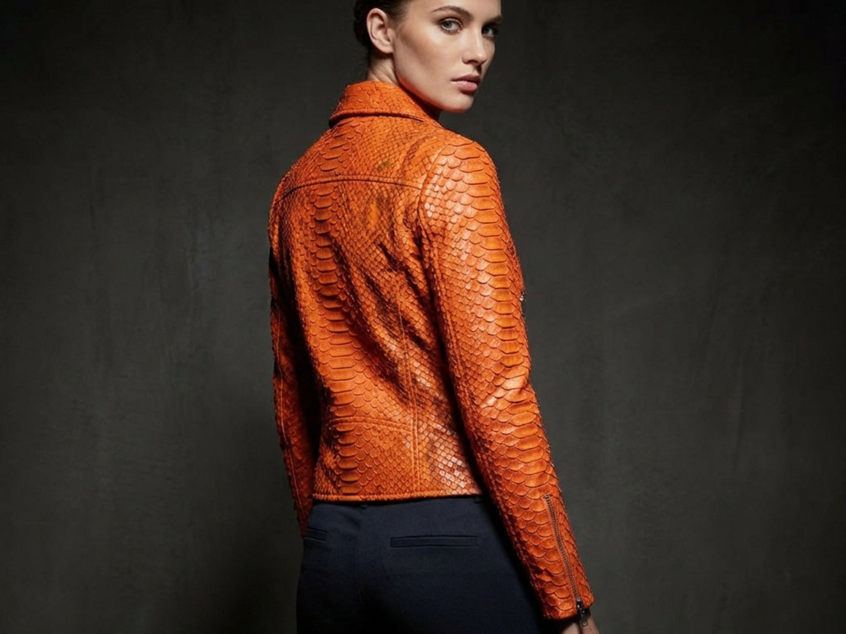 Burnt orange snakeskin-texture leather biker jacket back view with asymmetrical zip and shoulder seams