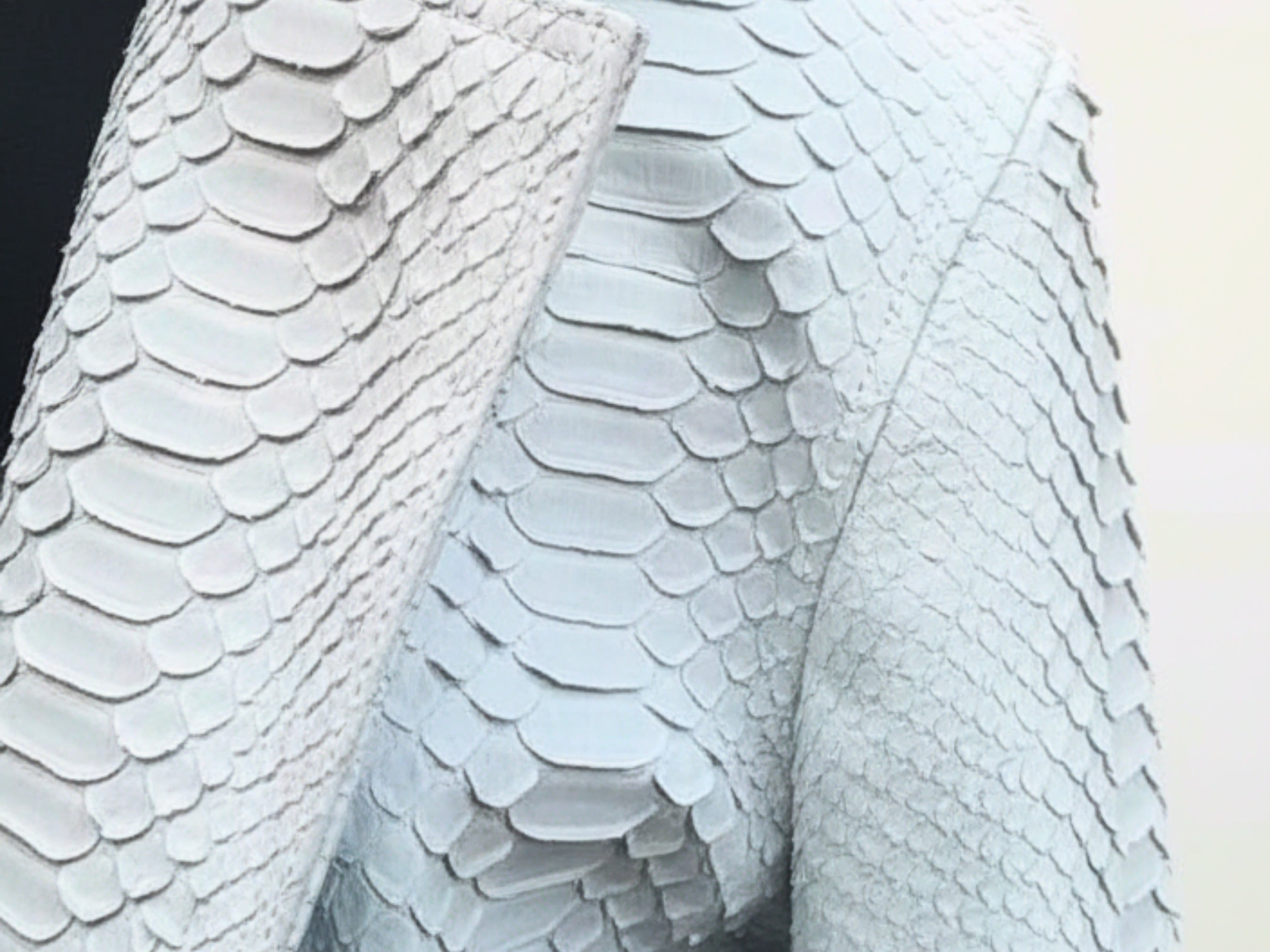 Close-up of light blue python-textured leather with scale pattern