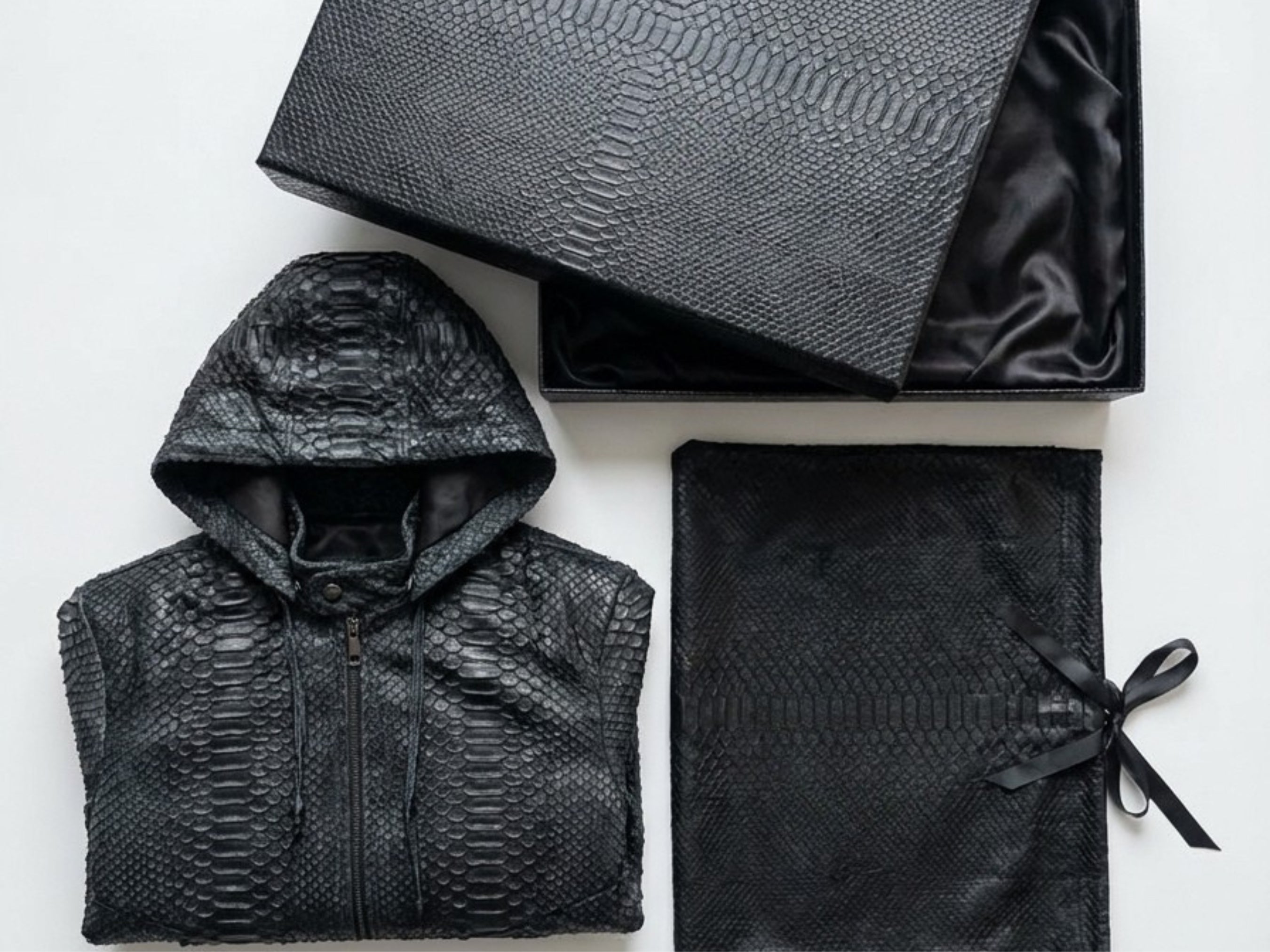 Python snakeskin hoodie bomber jacket folded, with hooded full-zip and black storage bag