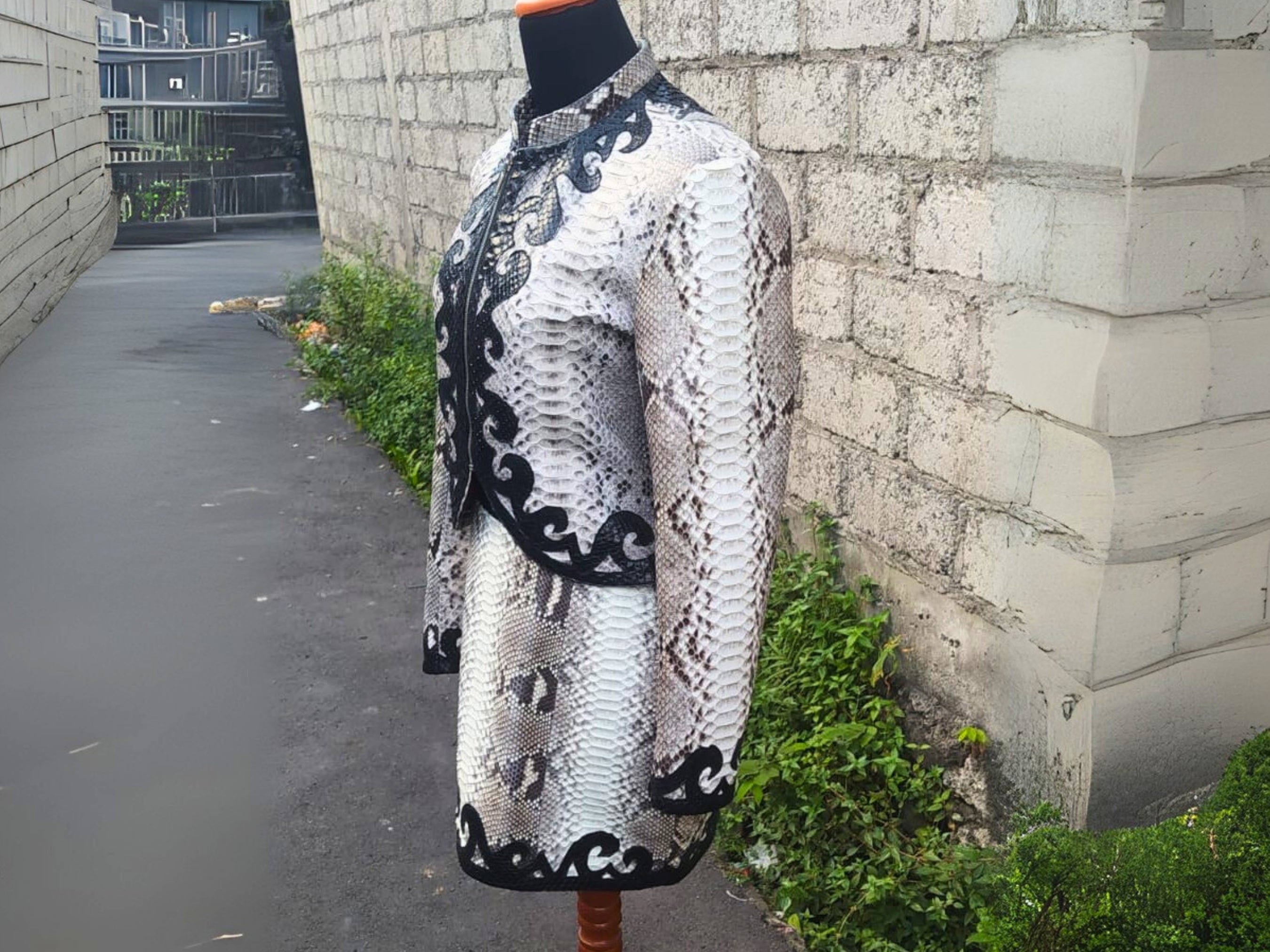 Snakeskin-print jacket and skirt set with black decorative trim, side view