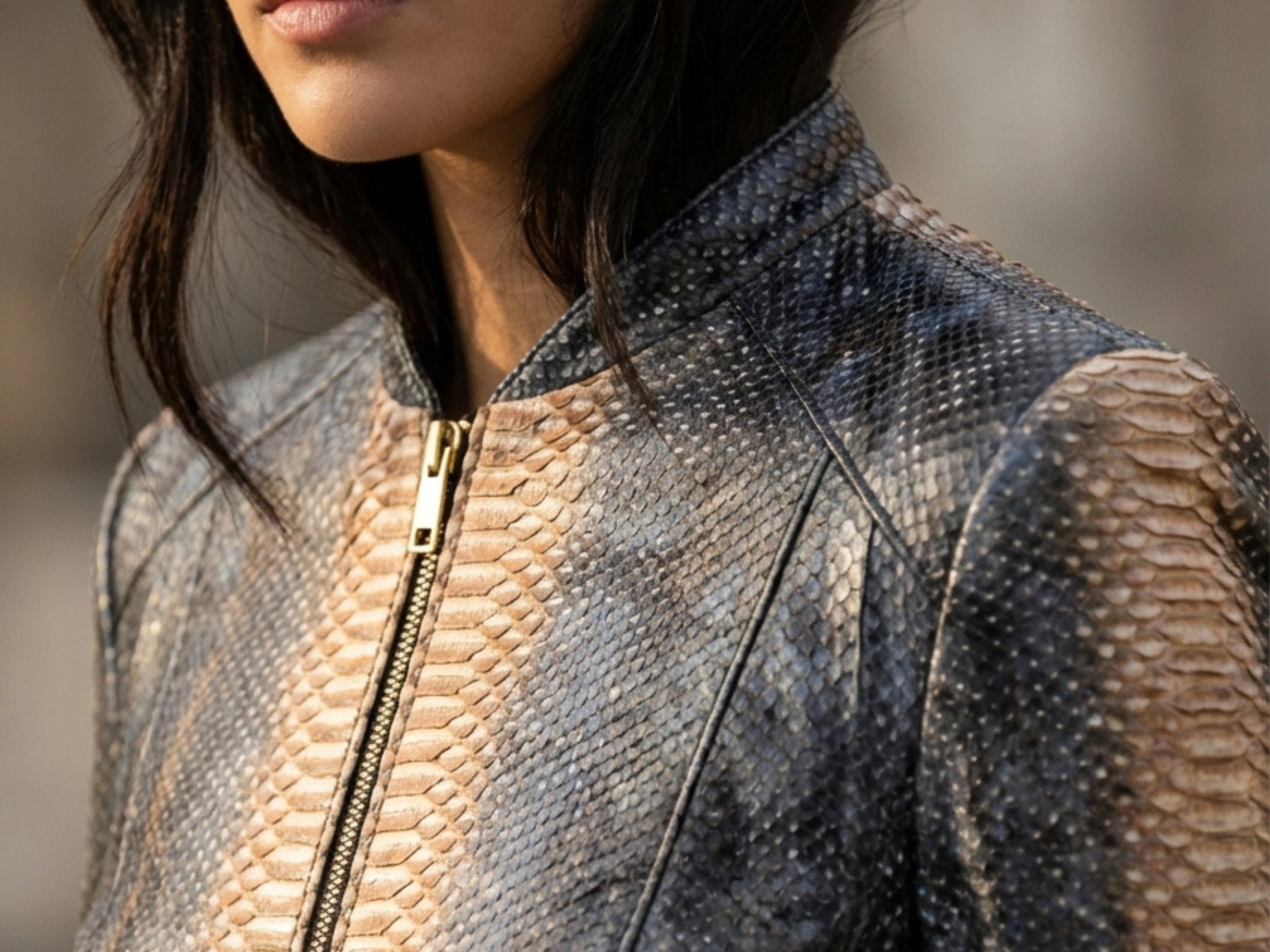Close-up of charcoal snakeskin-effect jacket collar with gold-tone zipper