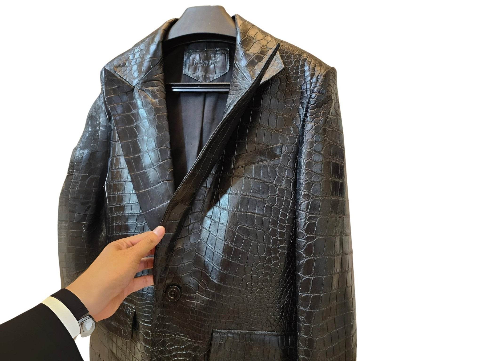 Alligator-skin jacket front detail with lapel and chest pocket, glossy scale texture.