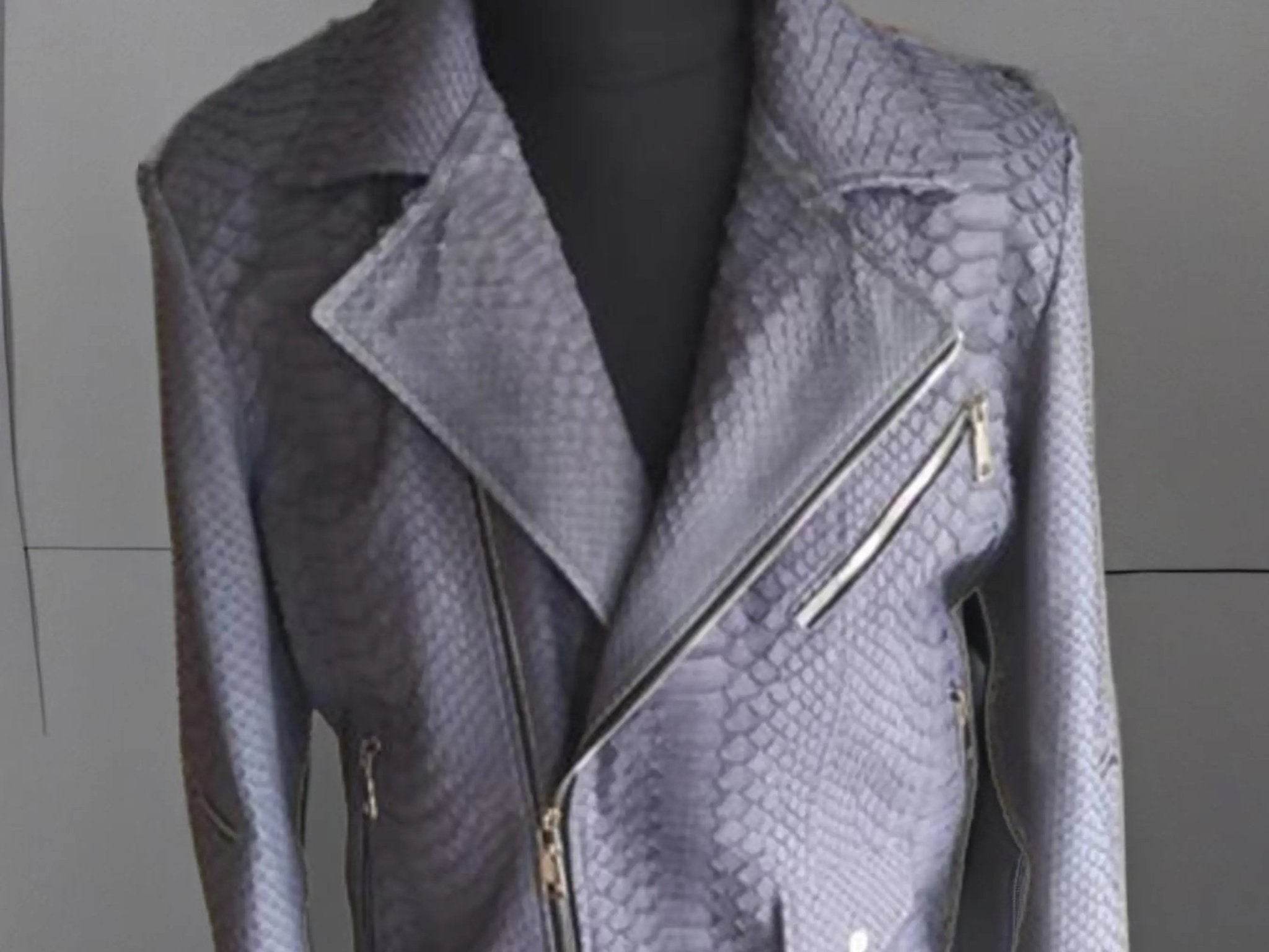Snakeskin leather jacket close-up, diagonal zip detail and gold-tone hardware