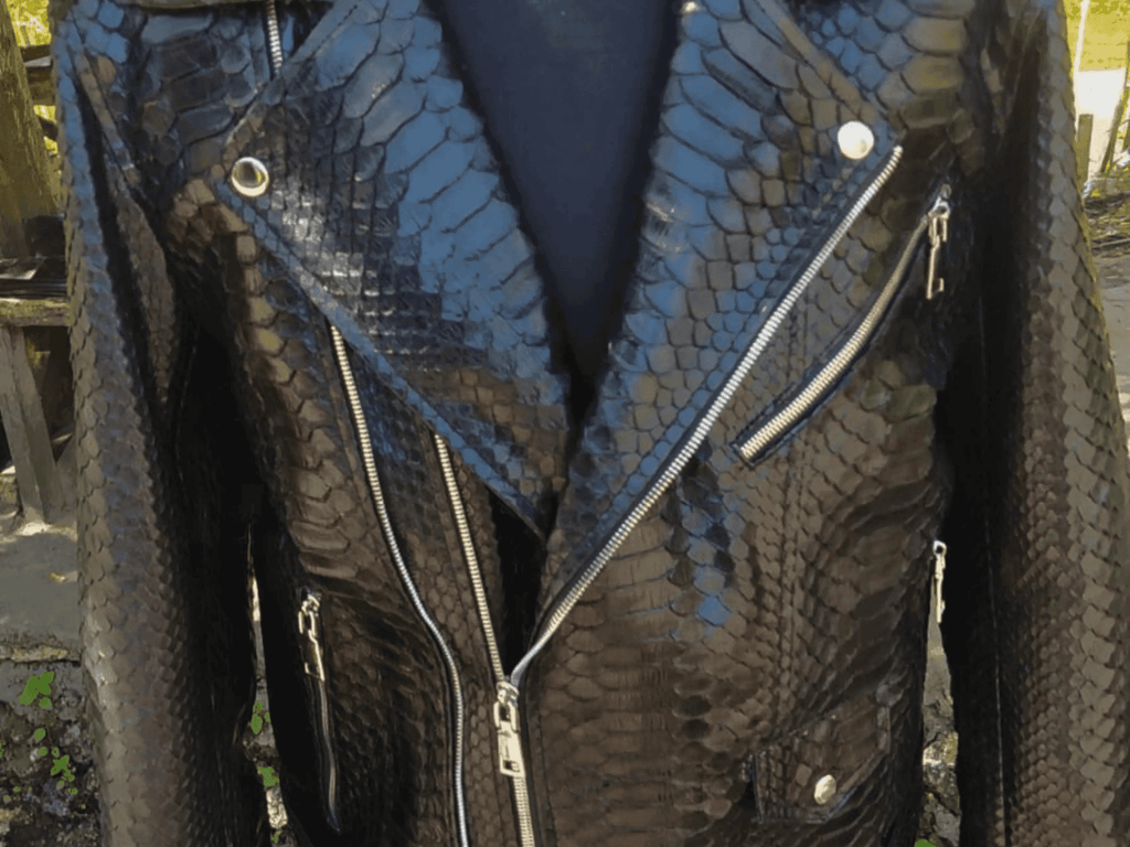 Close-up of python-skin leather motorcycle jacket chest with silver zippers and snaps