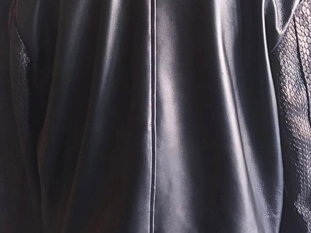 Black leather bomber jacket front panel close-up with zipper and glossy finish