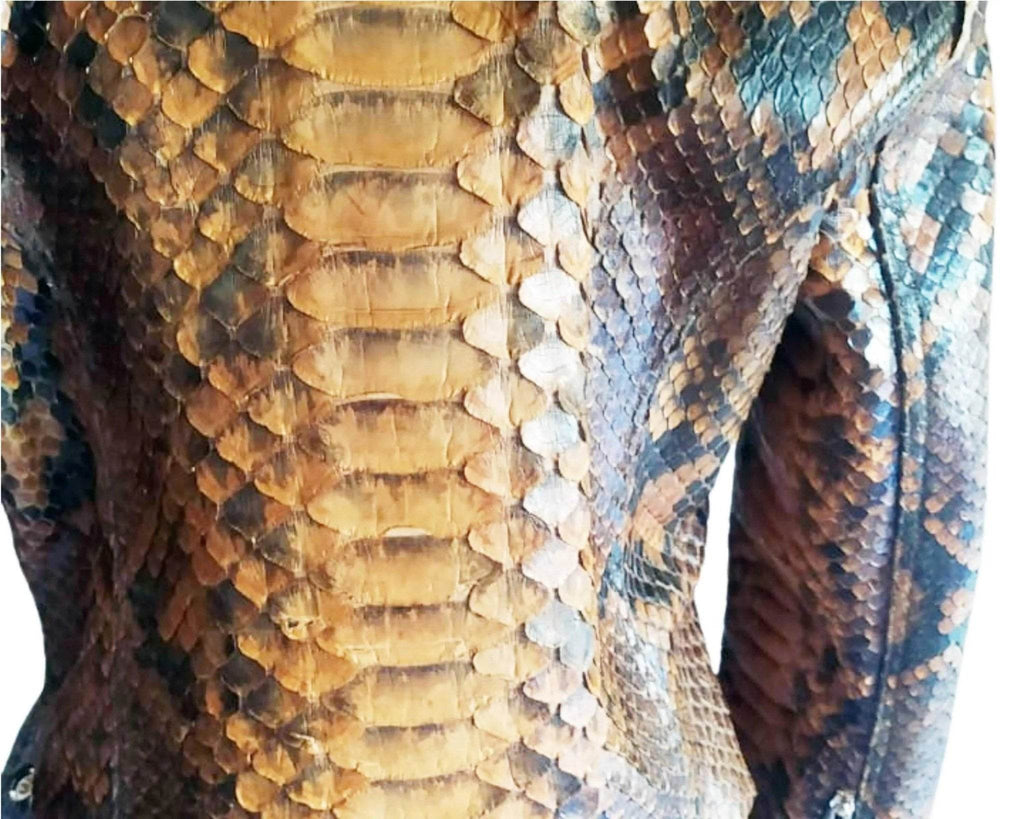 Close-up of snake-scale leather texture in gold, brown, and blue-gray tones