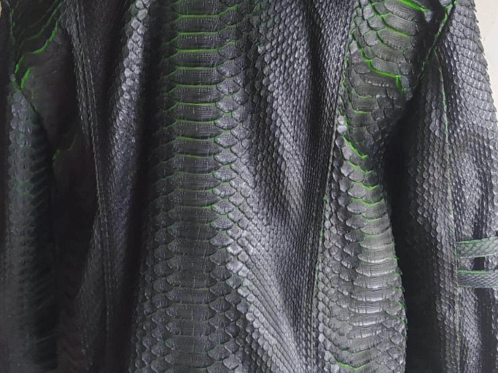 Motorcycle leather jacket close-up of king snakeskin texture with green accent stitching