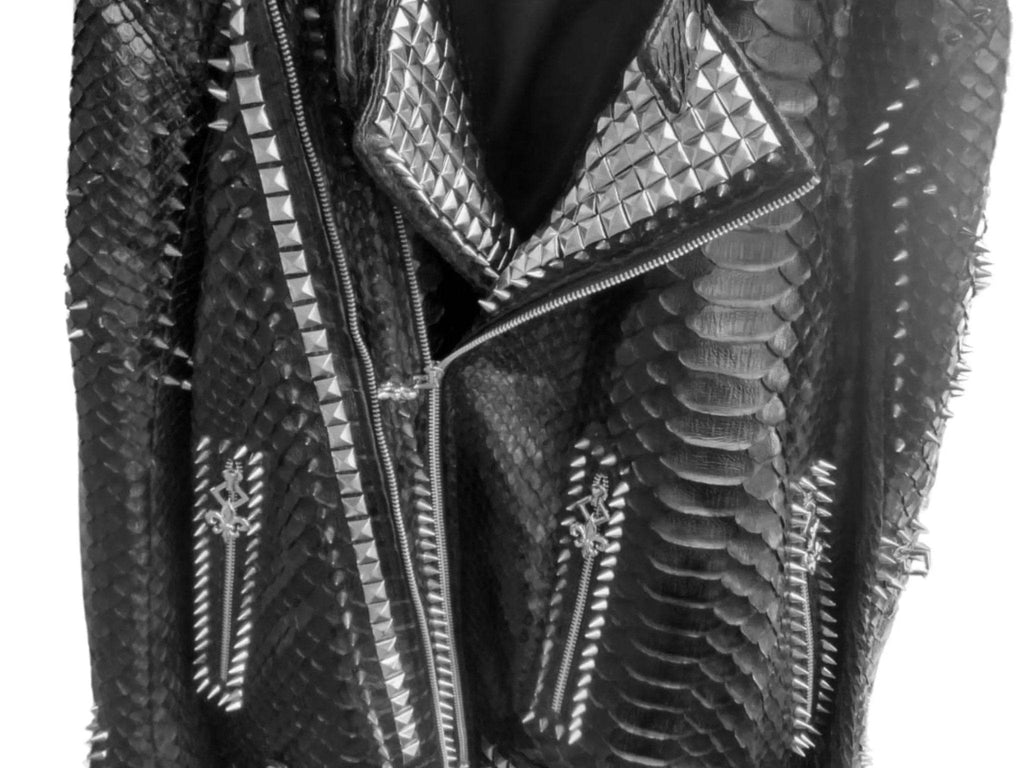 Leather jacket close-up showing snake-skin scales, multiple zippers, and metal trim