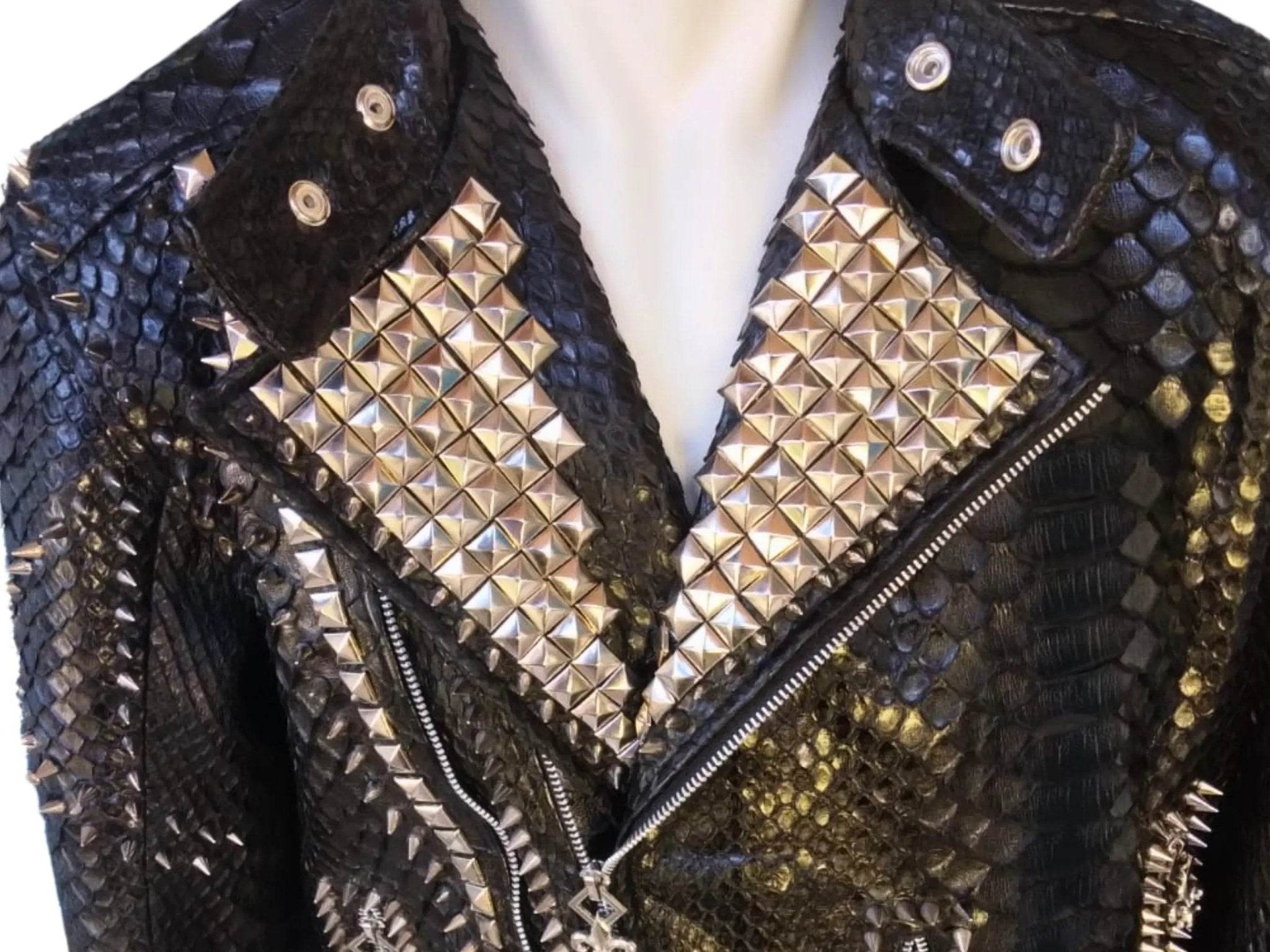 Leather jacket close-up: black scale texture with gold pyramid studs on lapels