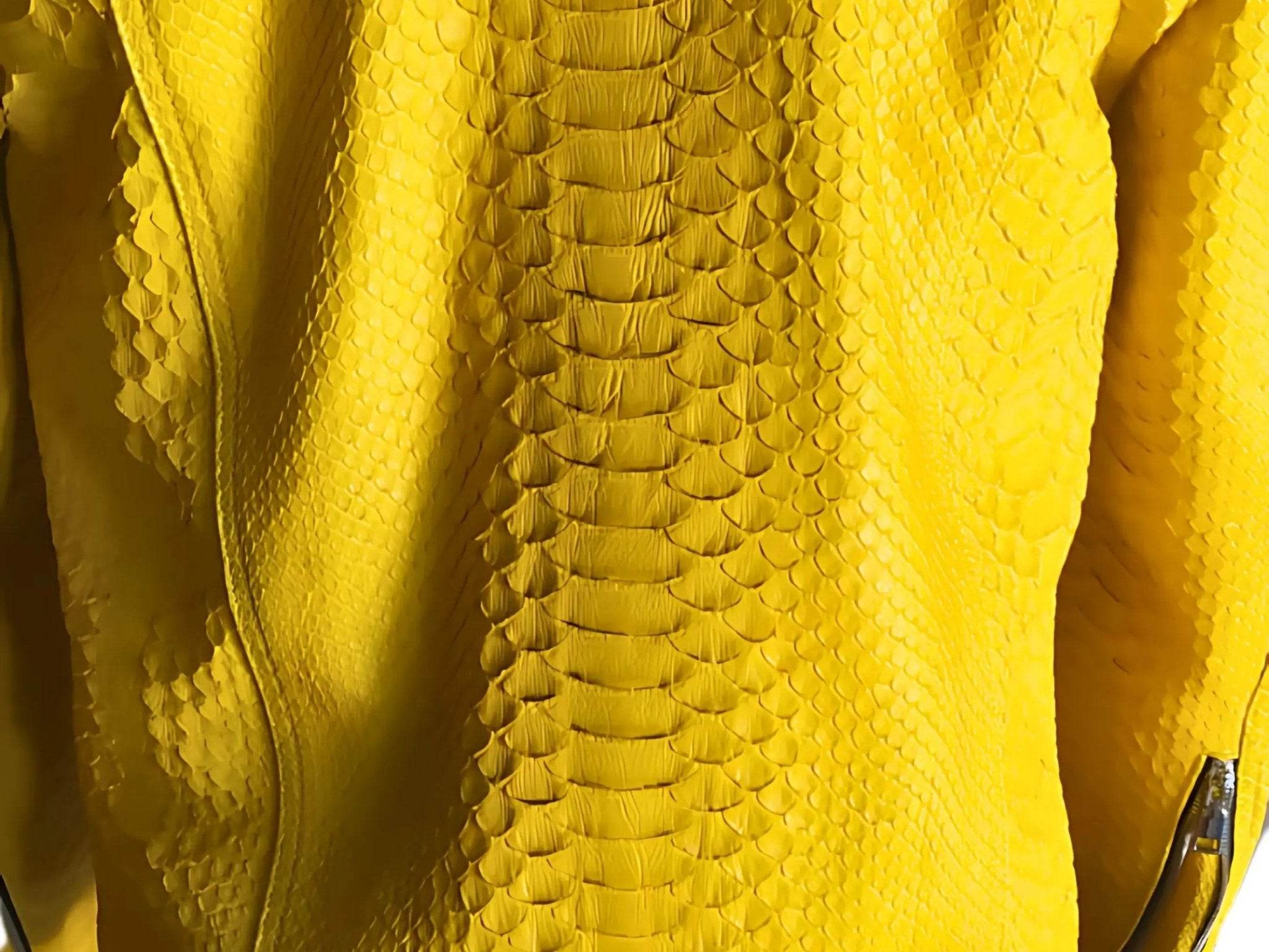 Yellow snakeskin-texture jacket fabric detail with raised scale pattern