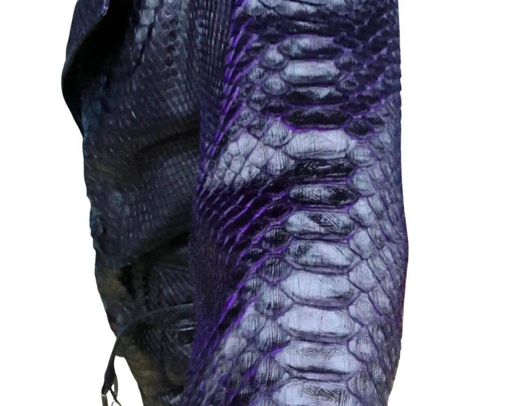 Snakeskin trench coat fabric detail with dark blue scale pattern and purple highlights.