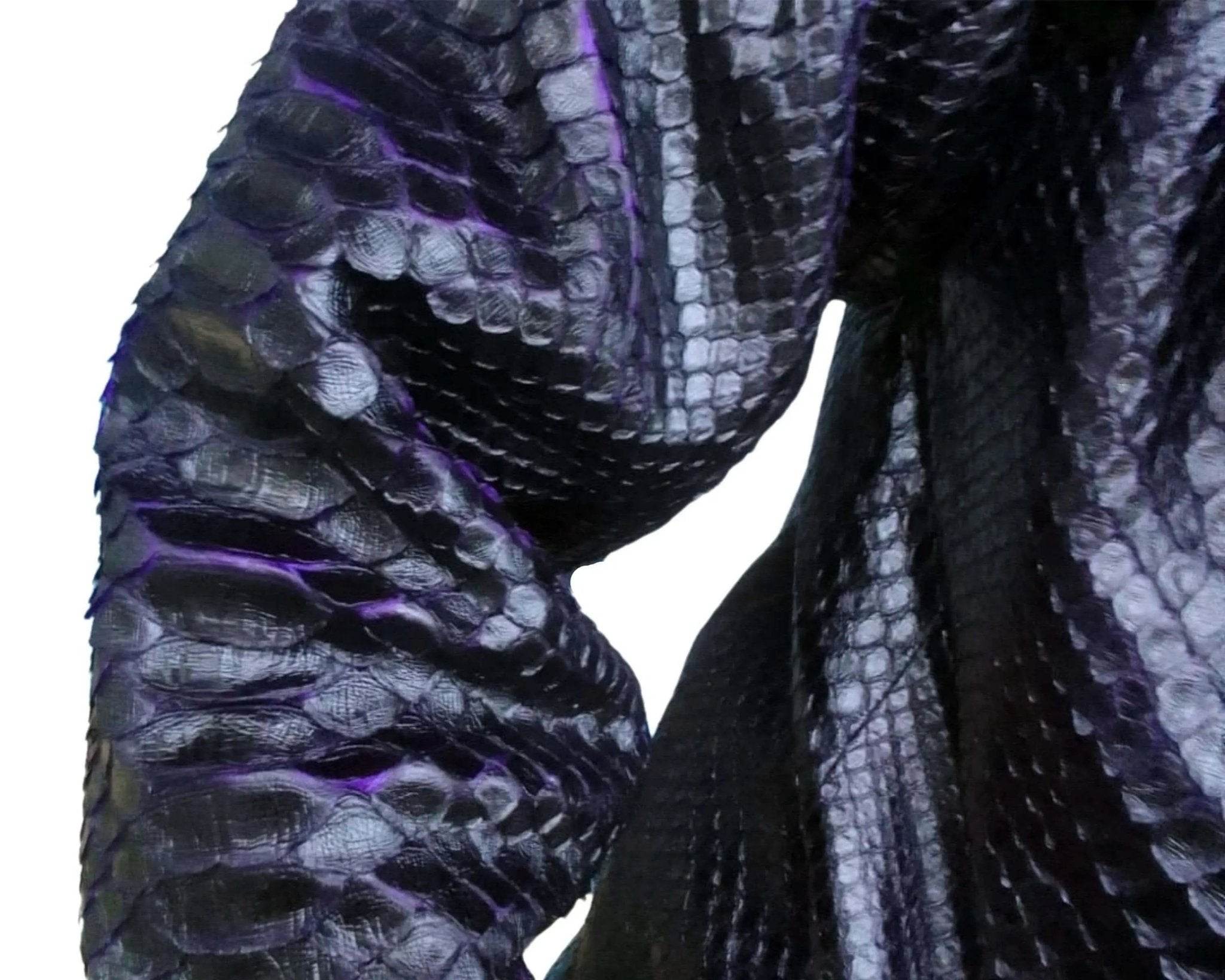 Snakeskin trench coat fabric detail in dark blue with subtle purple sheen.