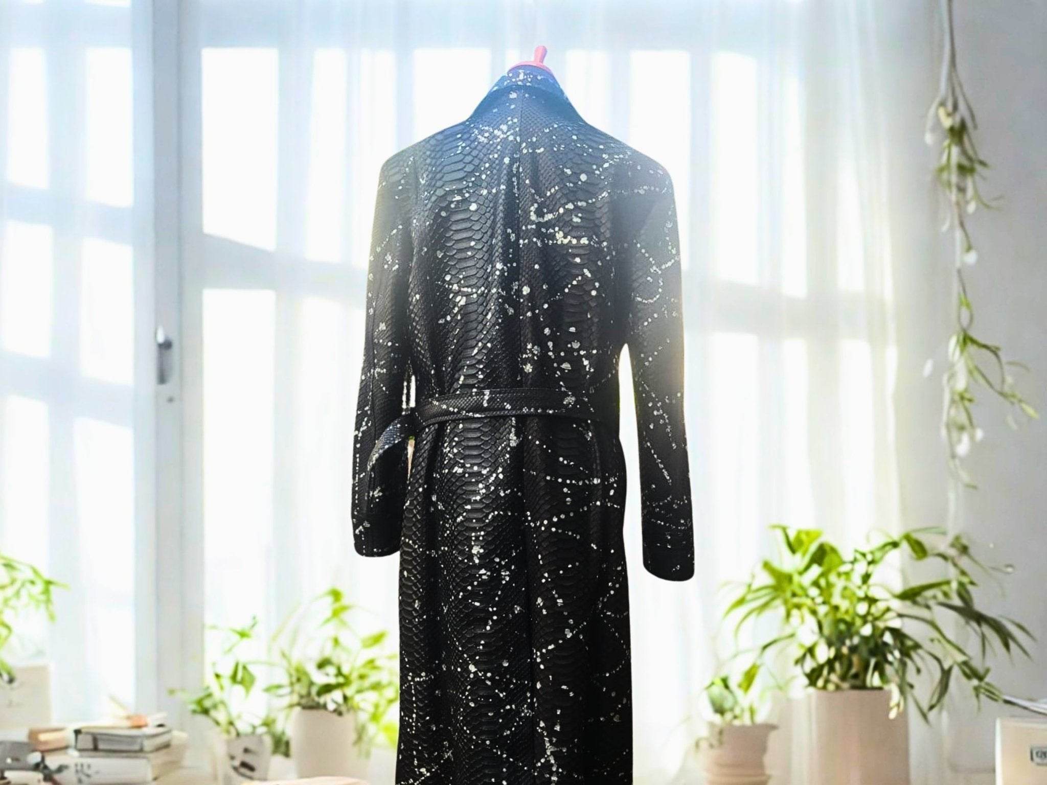 Dark long coat with snakeskin-inspired pattern and belt tie, rear view